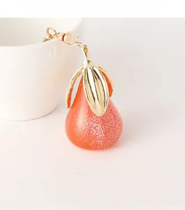 Vue détaillée d'un porte-clés poire orange avec paillettes sur une tasse en céramique