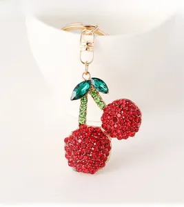 Close-up of cherry keychain with red and green rhinestones on gold metal ring
