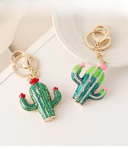 Detail of crystal-encrusted cactus keychain with gold spring clasp and pink flowers