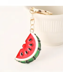 Close-up of watermelon slice keychain with red enamel and sparkling green rhinestones