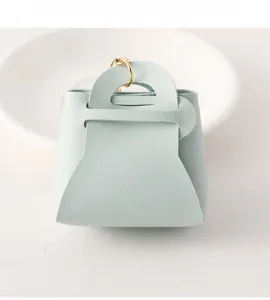 Detail of mint green lychee leather pouch with a gold metal ring on white porcelain