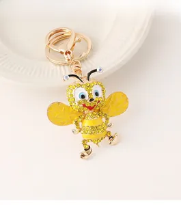 Detailed close-up of yellow rhinestone bee keychain with golden metal clasp and ring