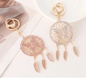 Close-up of elegant dreamcatcher butterfly keychains with pink crystals and feathers