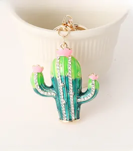 Detailed macro view of enamel cactus keychain with pink flowers and sparkling crystals