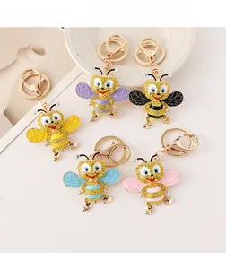 Close-up of sparkling rhinestone bumblebee keychains in five vibrant colors with gold rings