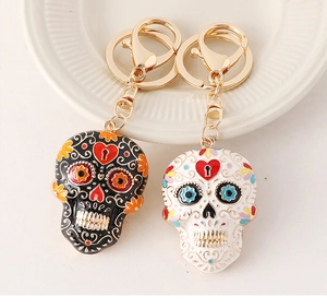 Detailed view of Mexican sugar skull keychains in black and white enamel finish
