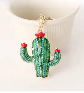Detail view of gold cactus keychain with green enamel and small blue rhinestones