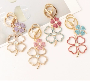 Detailed macro view of four leaf clover keychains with colorful rhinestones on gold alloy