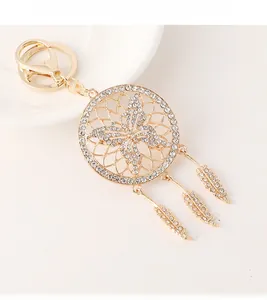 Detailed macro shot of a golden dreamcatcher keychain with butterfly wings and crystals