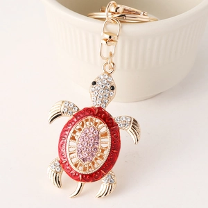 Goldener Schildkröten-Schlüsselanhänger mit roter Emaille und rosa Strasssteinen auf Keramik