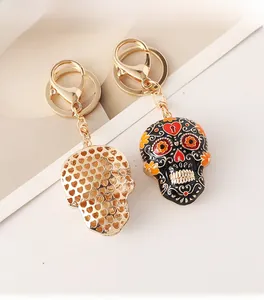 Detail of colorful enamel mandala skull keychain with golden metal heart mesh back