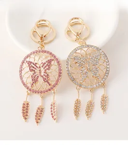 Detail of dreamcatcher butterfly keychains with rhinestones and hanging feathers