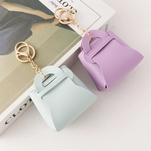 Miniature leather handbag keychains in pastel blue and purple with gold hardware