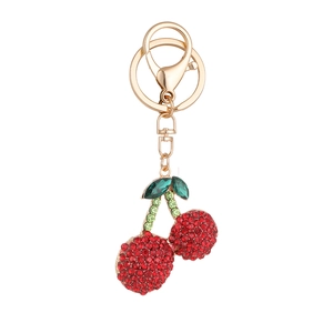 Red cherry keychain with sparkling rhinestones and golden lobster clasp on white background