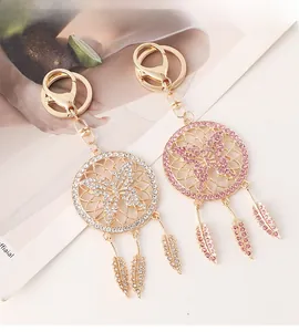 Detail of dreamcatcher keychains featuring golden butterfly charms and rhinestone feathers