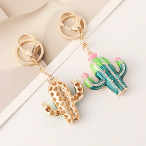 Sparkling cactus keychain with rhinestones and green enamel on elegant beige surface