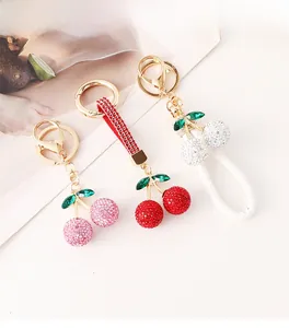 Détails de trois porte-clés cerises étincelants avec strass et lanières en cuir colorées