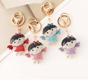 Détails de quatre porte-clés ange mignons sertis de cristaux et de strass colorés