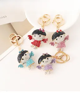 Détail de quatre porte-clés fille ange avec strass colorés et finition dorée