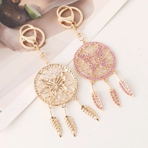 Golden dreamcatcher keychains with hollow butterfly and feather charms on a minimalist base