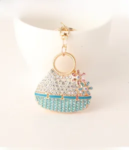 Detail of flower saddle bag keychain with blue crystals and golden lobster clasp