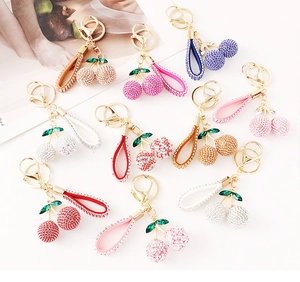 Macro shot of colorful crystal cherry keychains in gold finish with multiple color options