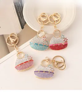 Detail of four colorful rhinestone flower handbag keychains with gold metal hooks