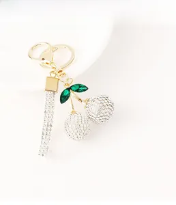 Detailed view of cherry keychain with sparkling rhinestones and golden hardware