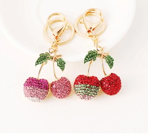 Detailed macro of sparkling cherry keychains with rhinestones and gold lobster clasps