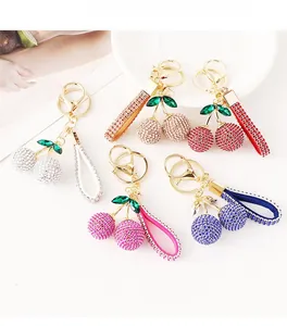 Detail view of cherry keychains in five colors with sparkling rhinestones and gold plating