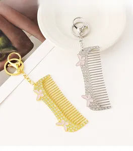Detail of crystal-encrusted comb keychains in gold and silver with pink butterfly accents
