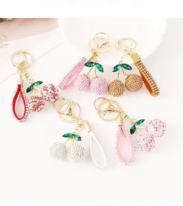 Detailed view of assorted rhinestone cherry keychains with green gem leaf accents