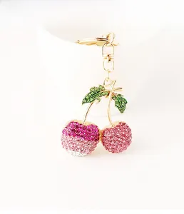 Detail of sparkling crystal cherry keychain with green leaves and golden lobster clasp