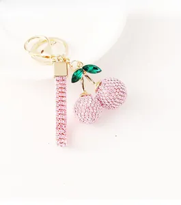 Detail of pink rhinestone cherry keychain with green crystal leaves and golden lobster clasp