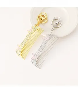 Detailed view of hair comb keychain with white rhinestones and pink butterfly enamel charms