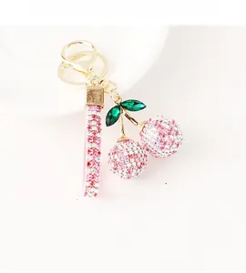 Detail of pink rhinestone cherry keychain with sparkling gems and gold-plated hardware