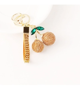 Detailed shot of cherry keychain with gold rhinestones and emerald green leaf stones