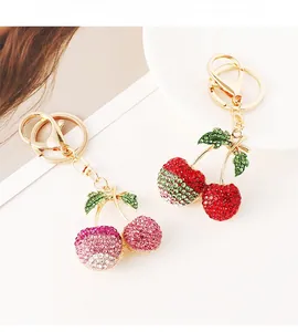 Close-up of sparkling rhinestone cherry keychains with gold-plated lobster clasps