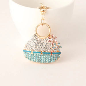 Sparkly handbag keychain with blue and white crystals and floral accents in gold metal