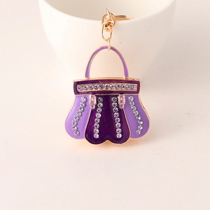 Detailed macro view of purple enamel handbag keychain with sparkling rhinestones and gold ring