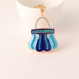 Detail of blue enamel handbag keychain with sparkling rhinestones and gold alloy hardware