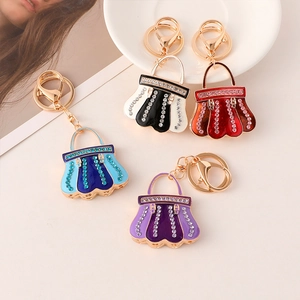 Detail of colorful enamel handbag keychains with rhinestones and golden tassels