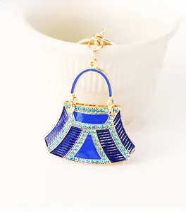 Detail shot of golden handbag keychain with deep blue enamel and light blue rhinestones