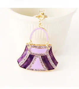 Detailed macro view of purple enamel handbag keychain with shimmering crystal accents
