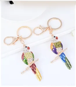Détails des porte-clés perroquet dorés avec strass colorés et finition en émail