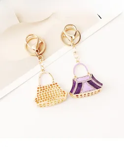 Detail of luxury rhinestone handbag keychains in gold and purple crystal finishes