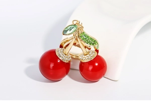 Gros plan d'un pendentif cerise avec perles rouges et feuille en strass étincelants