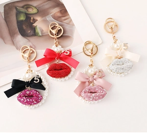 Detail showing crystal lips keychains with silk bows and pearl charms in four colors