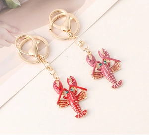 Detailed close-up of red and pink enamel lobster keychains with sparkling rhinestones
