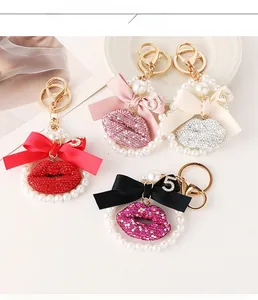 Detail of glittery lips keychain with ribbon bow and pearl ring in various colors